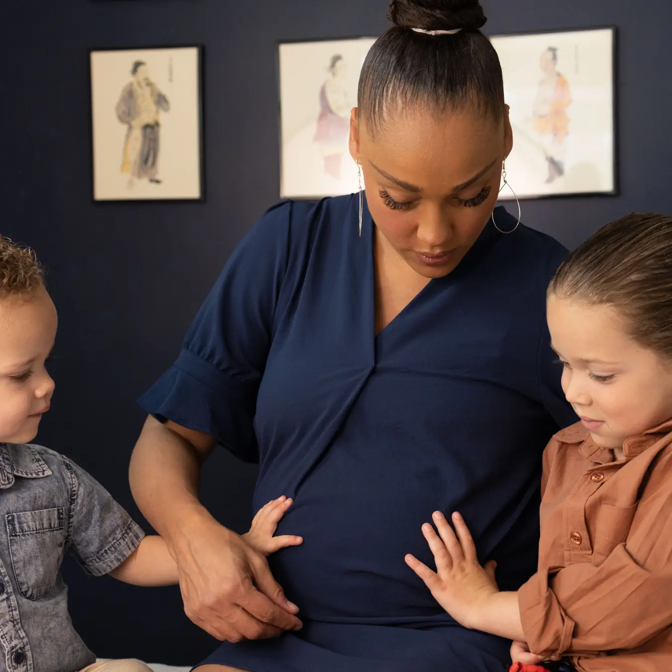 Practitioner supporting a mother and children for pregnancy and postpartum wellness